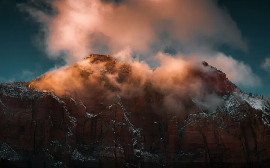 Red rock mountain ridge wreathed in cloud