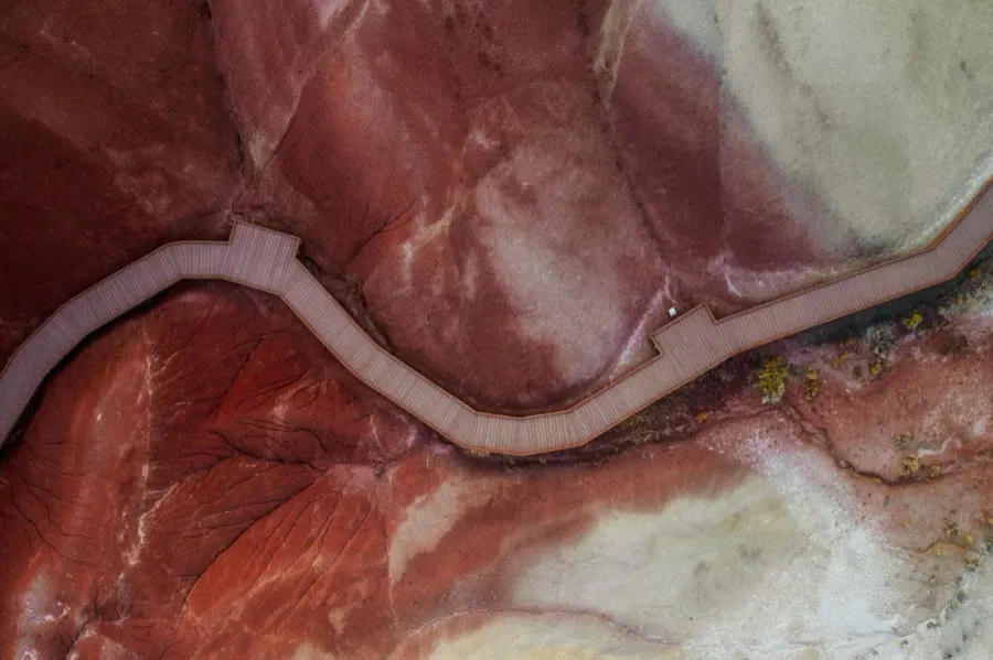 Aerial view of a river winding through banded red and white sediment